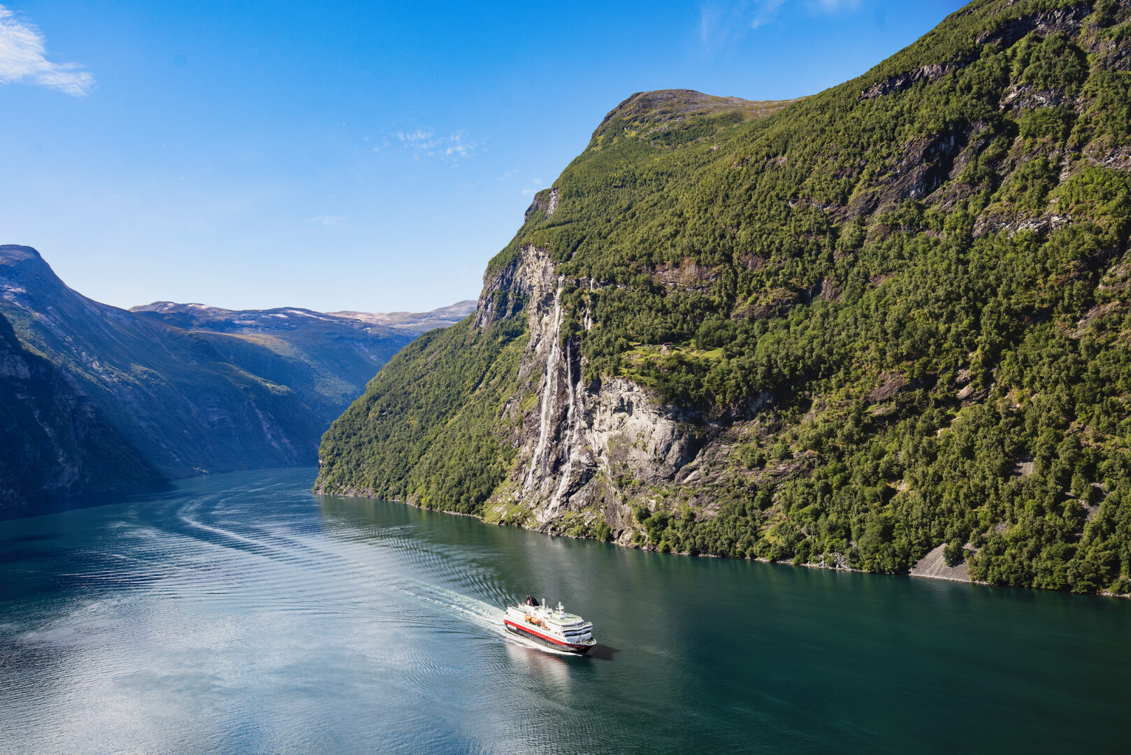 nyd stilheden i fjordene og landskabet vi passere. Efter at har krydset det åbne hav, navigerer skibet i den tidlige morgenstund mellem skær og øer til jugendstilperlen Ålesund. Fra 2/6-1/9 sejles ind i Norges kronjuvel, den overdådig smukke Geirangerfjord som står på UNESCOs verdensarvsliste